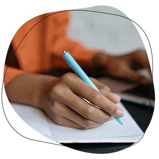 Someone writing copy on paper and computer